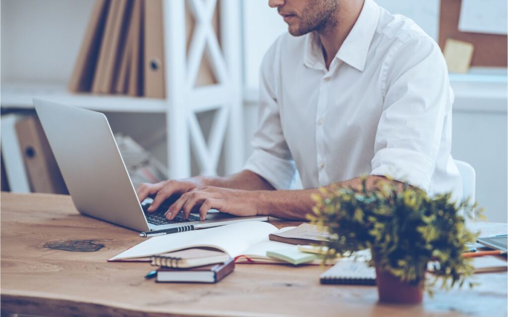 home treballa a l'oficina amb portàtil